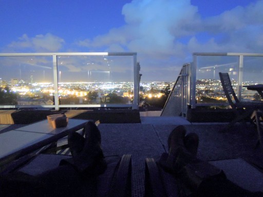 Two sets of booted feet, propped up on a rooftop deck