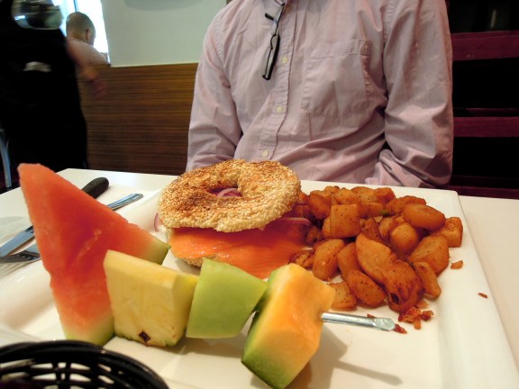 Erik's breakfast: fruit, smoked salmon and cream cheese on a bagel, potatoes.