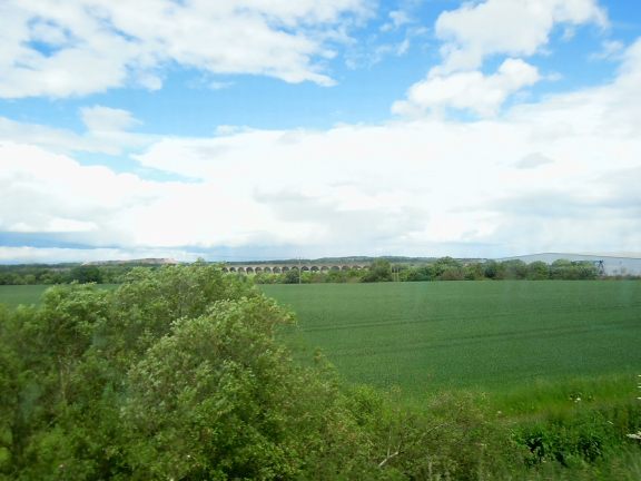 View from train to Edinburgh: grass and a stone bridge