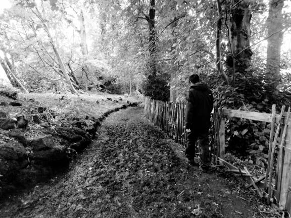 Erik picking his way across a muddy patch of trail (B/W)