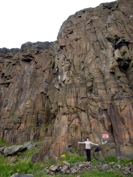 Lisa standing by tall cliffs