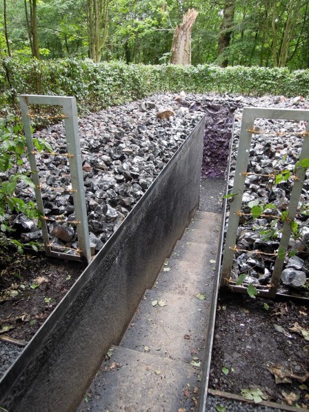 That's a very narrow passageway, only wide enough for one person to walk through Narrow passageway with stairs leading into the underground chamber