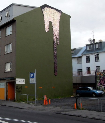 Multi-story building with a shimmering "drip" artwork on the wall