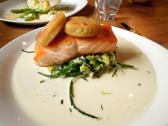 One of the tastiest dishes I've ever eaten, I'm pretty sure. Small fried flat round cakes on top of a filet of salmon on top of a bed of vegetables, in a light cream sauce.