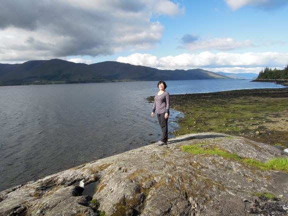 Lisa standing on a boulder next to Loch Linnhe
