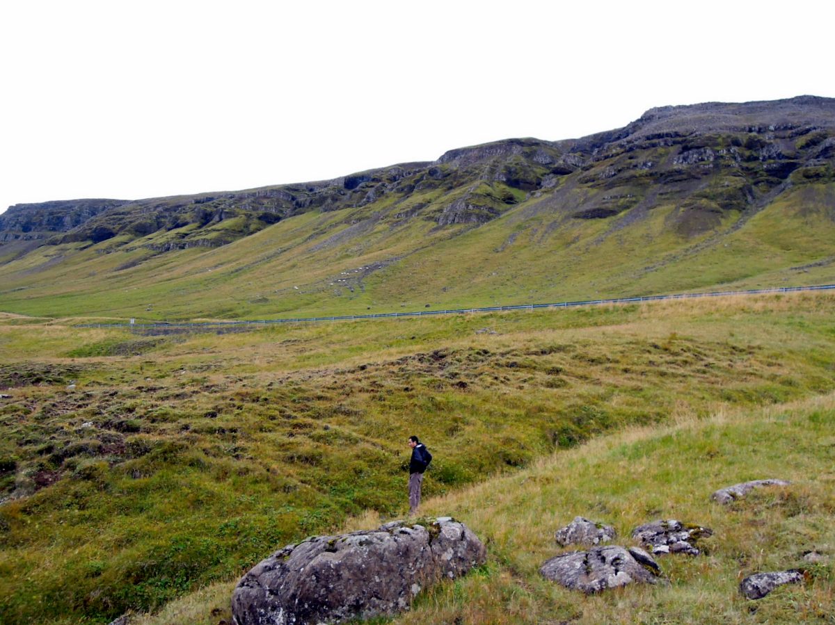 Erik walking on a hill with a mountain behind