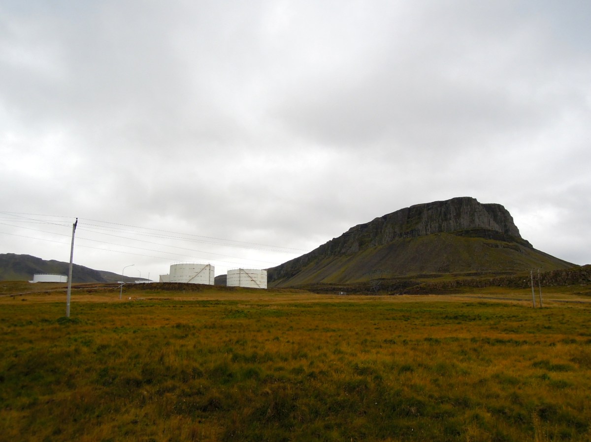 Dramatic mountain with some kind of holding containers (?) next to it