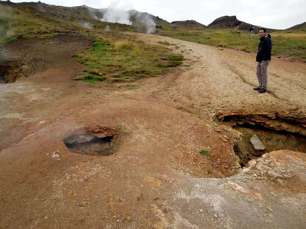 Erik standing on uneven ground with holes in it