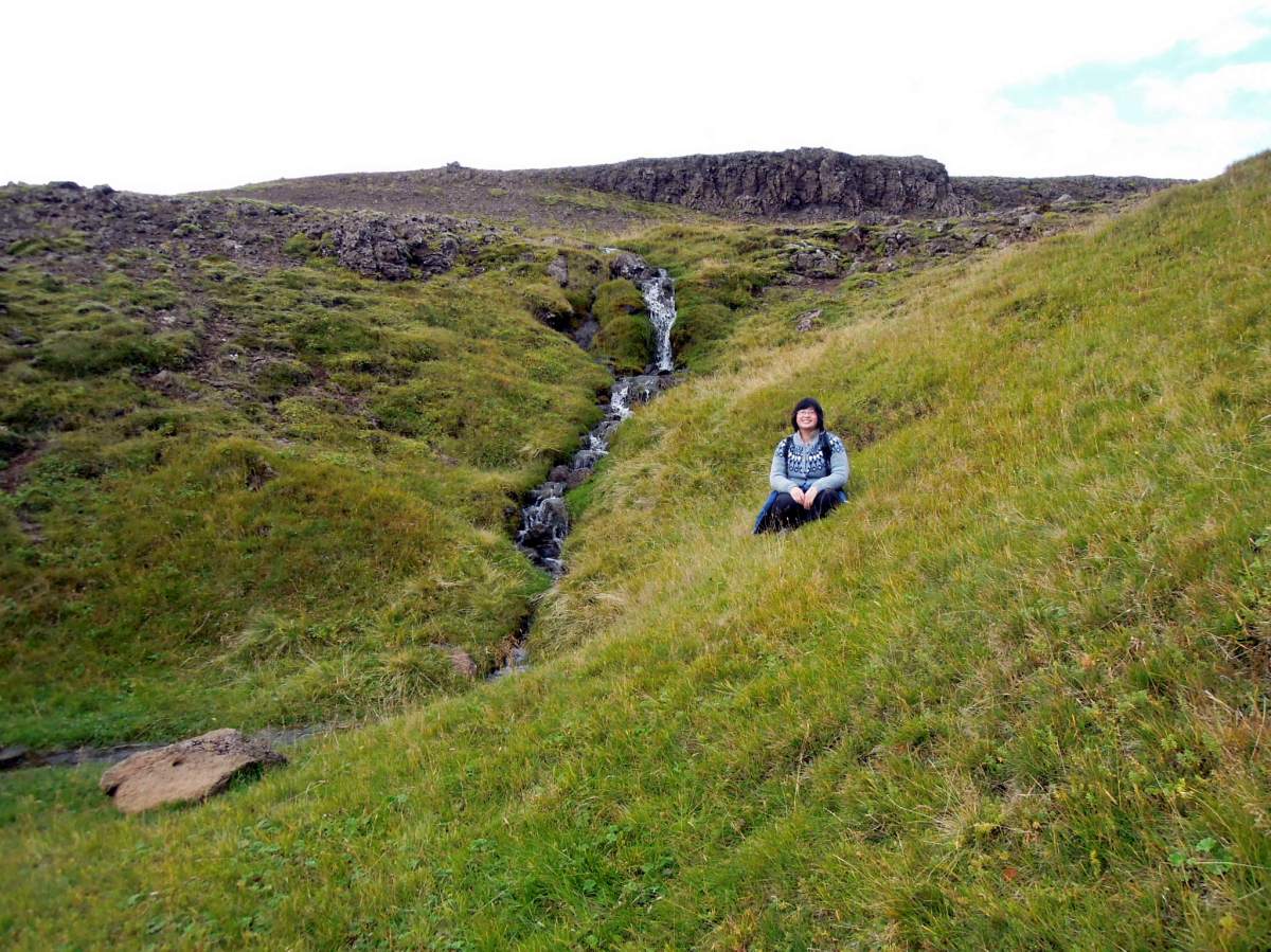 Lisa sitting next to a small waterfall
