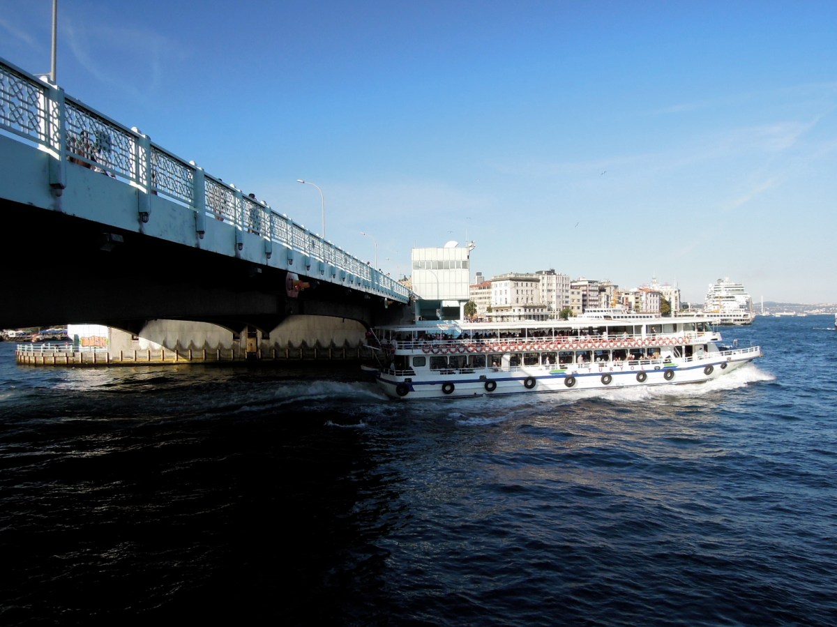 Boat passing under the Galata Bridge