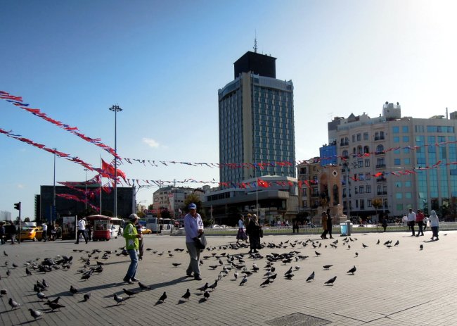 People, pigeons, and bunting on Taksim Square