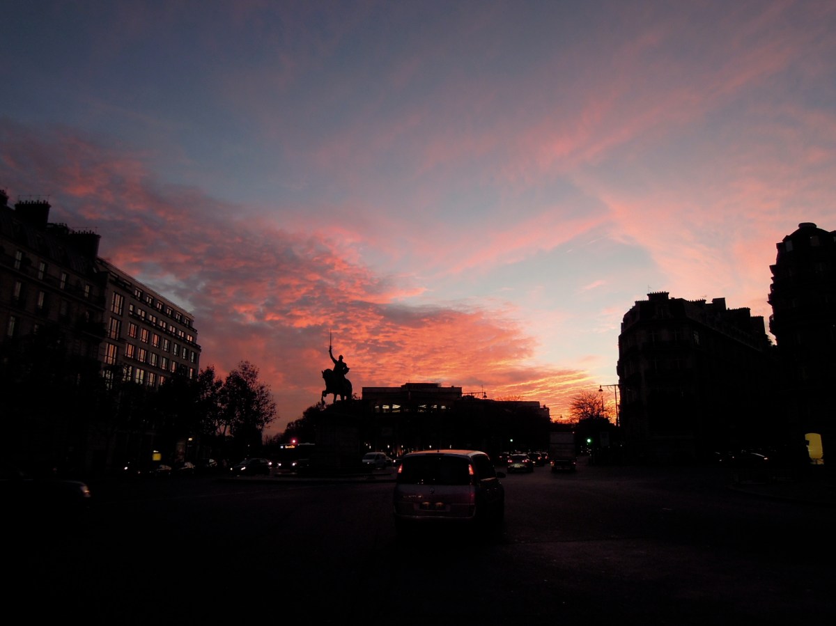 Statue of an equestrian George Washington, silhouetted against a pinky-red sunset