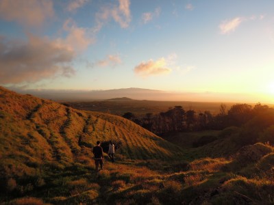 Angela and Erik walking on hillside as sun goes down