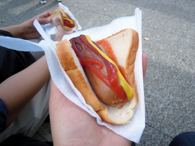 Sausage with ketchup and mustard, on white bread