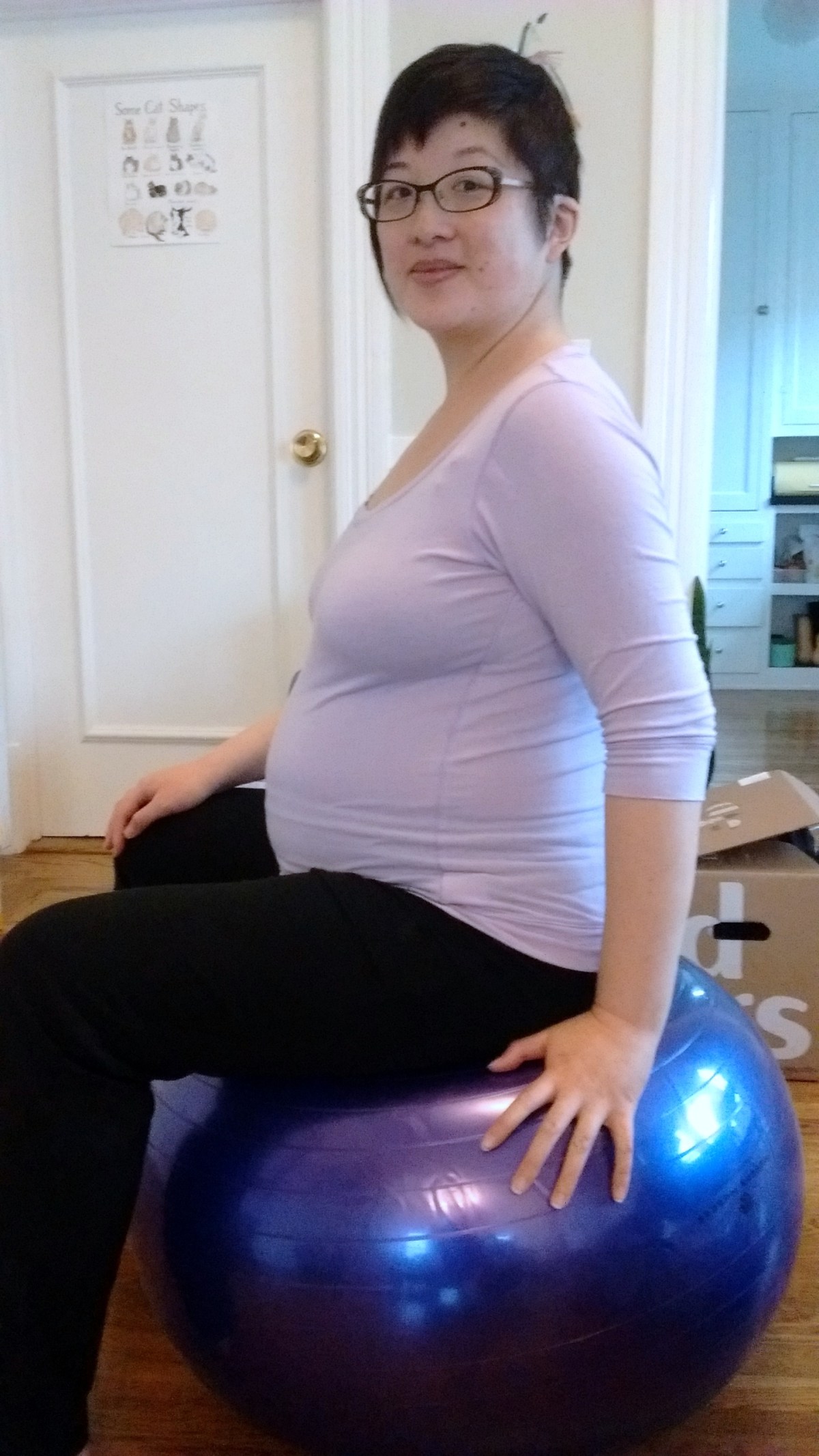 Lisa at 8 month pregnant sitting on fitness ball
