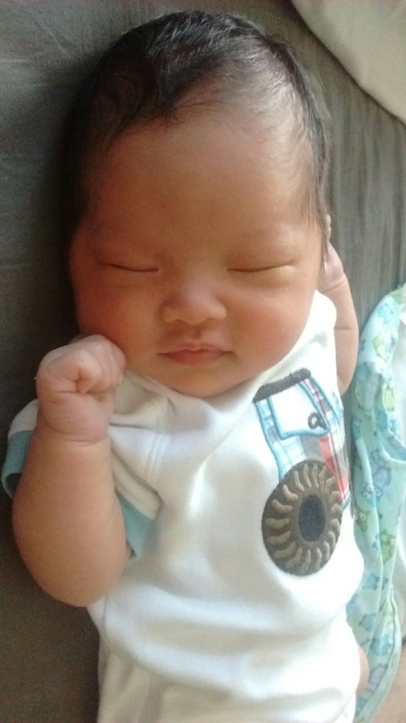 Ada at three weeks old, sleeping and smiling