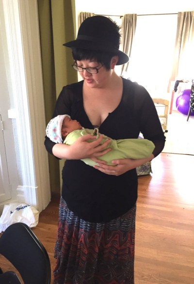 Lisa holding baby Ada in a swaddle sack