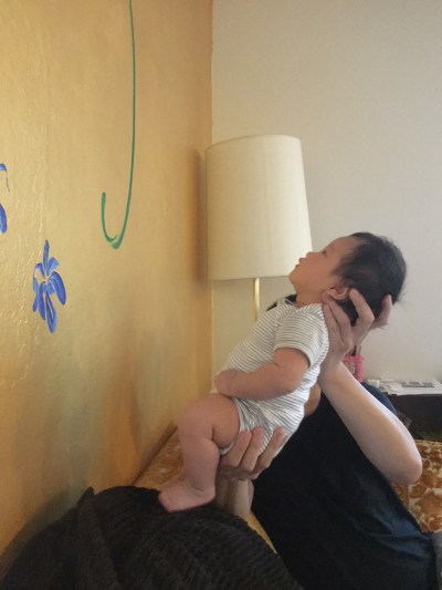 Baby Ada being held up to look at a decorated wall