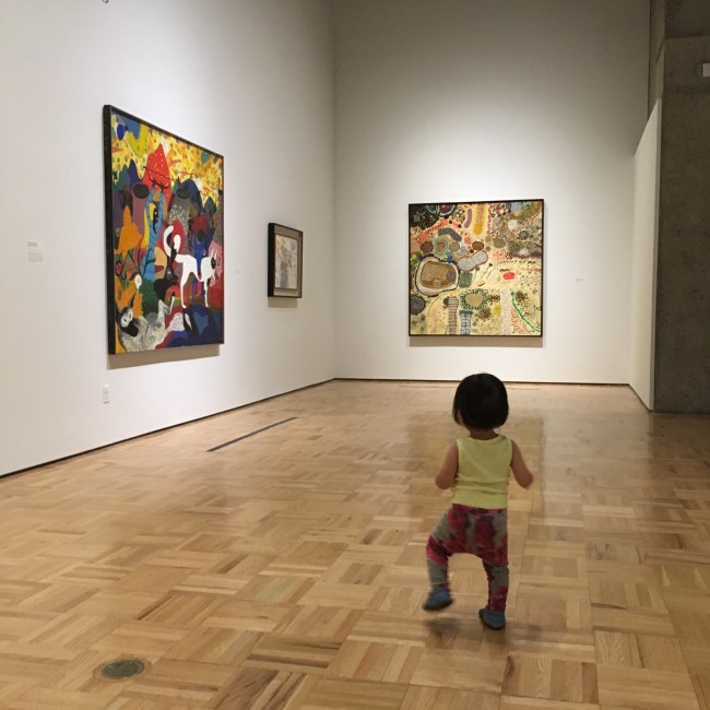 15-month-old Ada walking through the Roy De Forest exhibition at the Oakland Museum