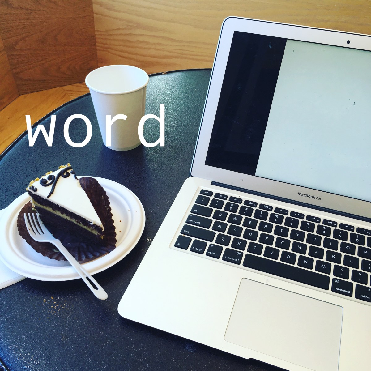 The word "word" imposed over a photo of a laptop open to a blank document, with a coffee cup and a slice of cake next to it