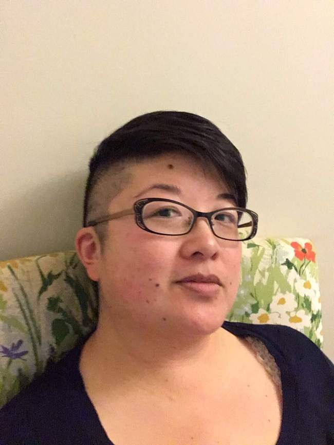 38yo Asian American person with short hair, shaved sides, and black-framed glasses