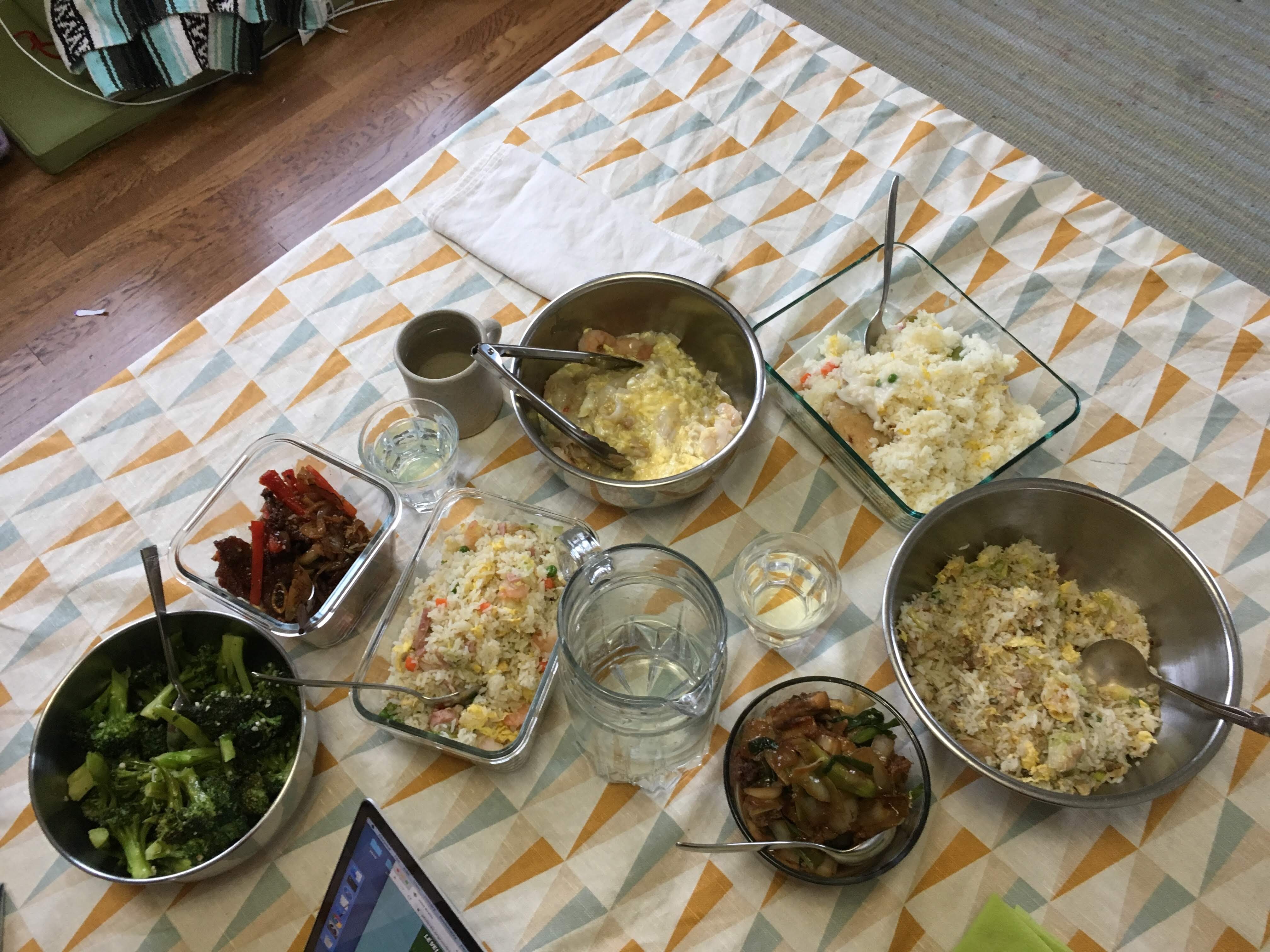 Assortment of Cantonese restaurant dishes decanted into bowls and plates and food-storage containers