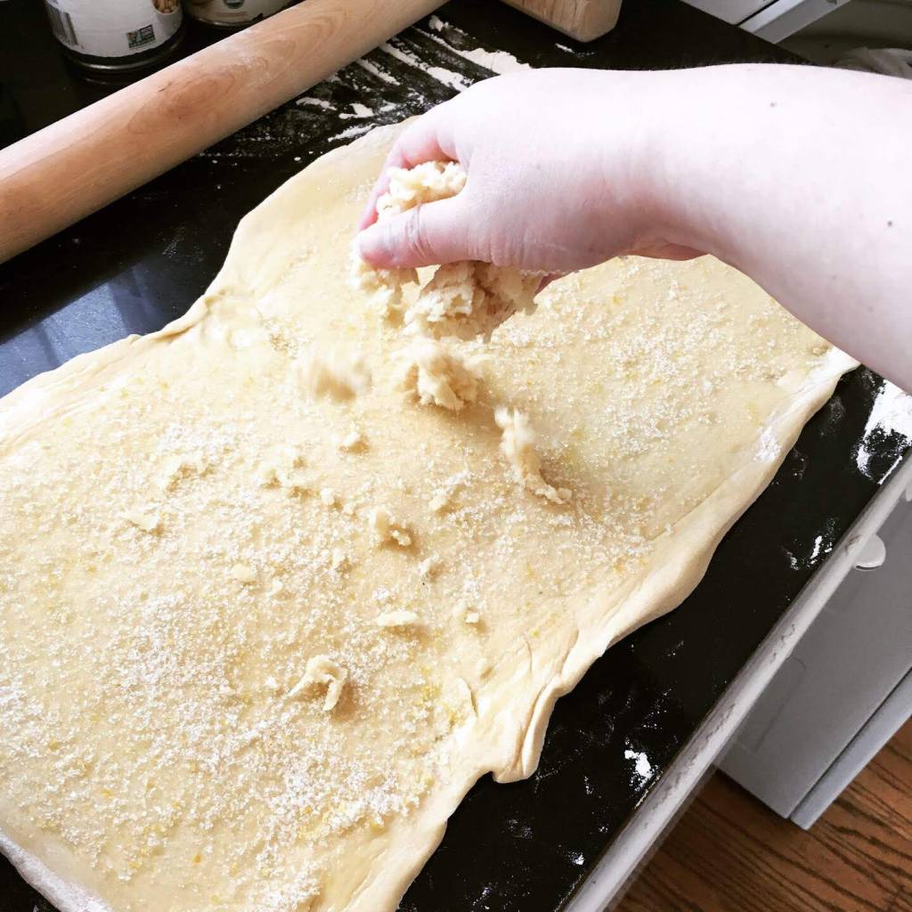 Sprinkling almond paste onto dough