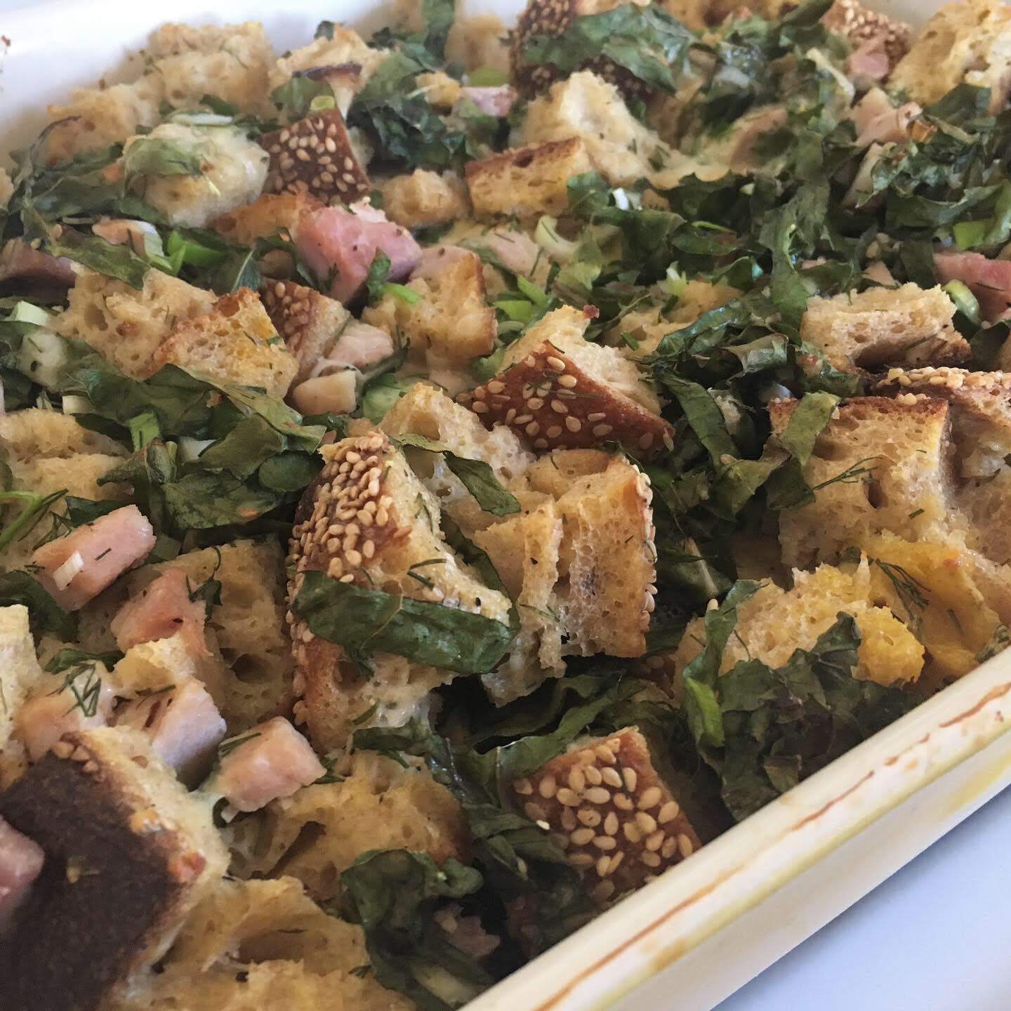 Savory bread pudding with ham, sesame bread, and greens