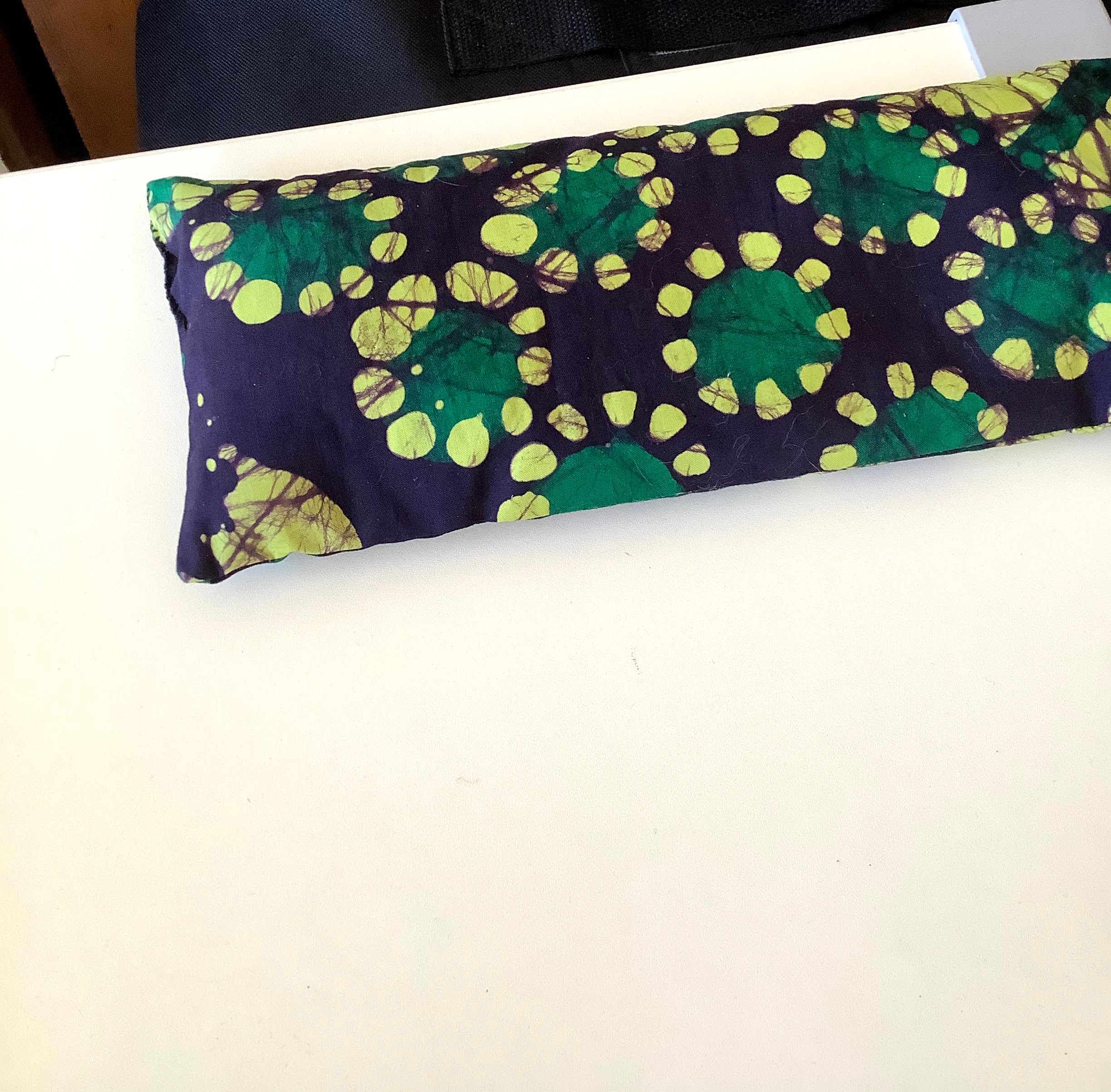 Dark blue eye pillow with wax print of dark and lighter green circles