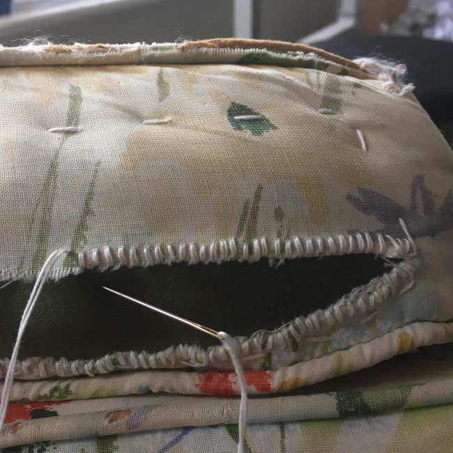 A ripped ottoman being mended