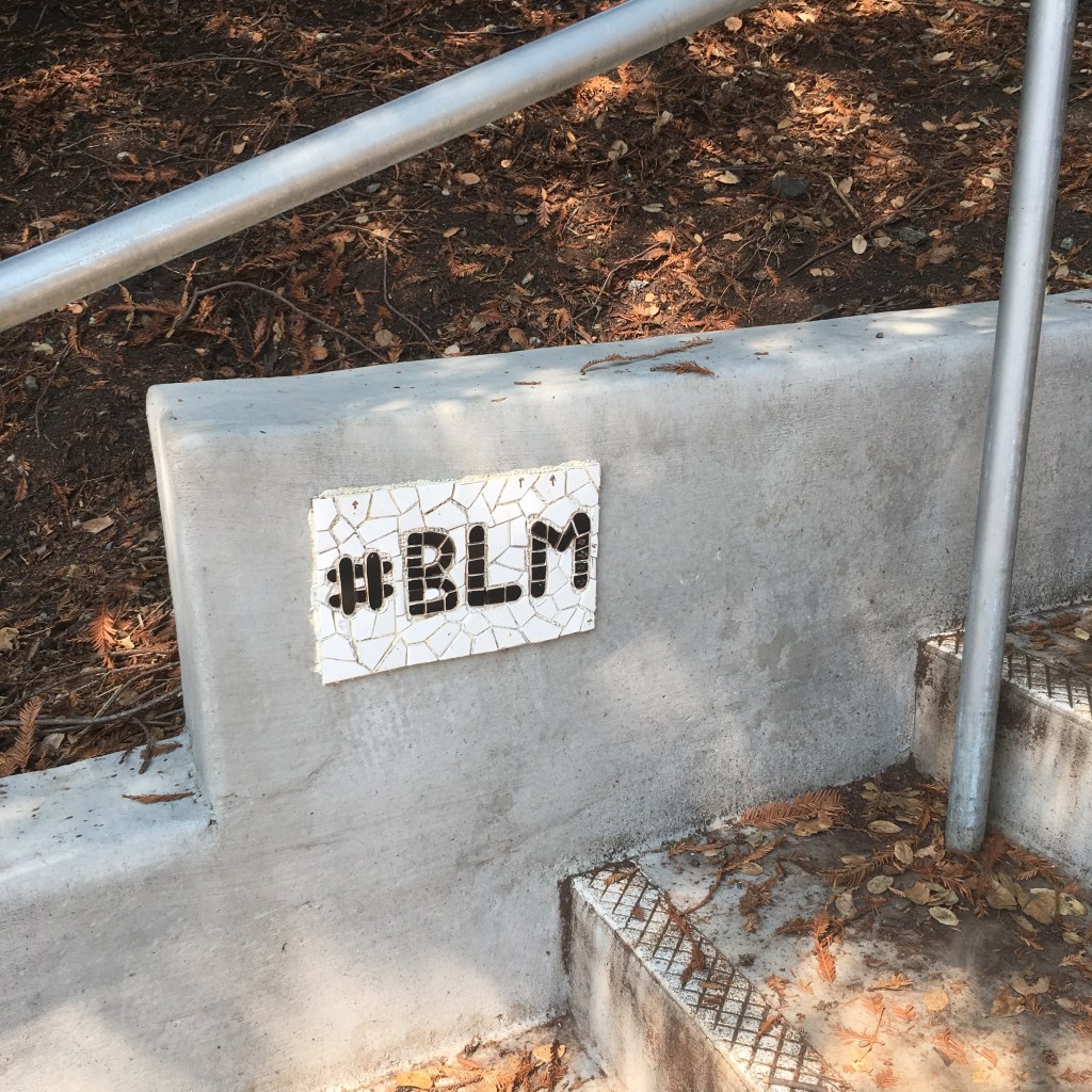 Black and white #BLM mosaic affixed to a concrete wall in Joaquin Miller Park